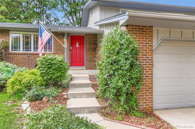 a front view of a house with plants
