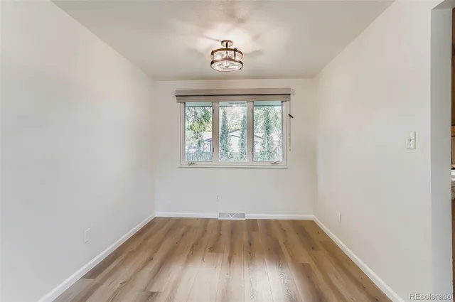 an empty room with a window and wooden floor
