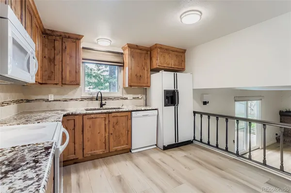 a kitchen with stainless steel appliances granite countertop a refrigerator sink and white cabinets