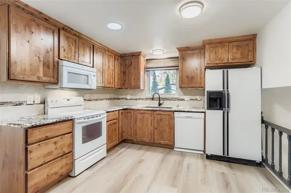 a kitchen with stainless steel appliances granite countertop a stove sink and cabinets