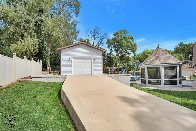 a view of a white house with a yard and garage