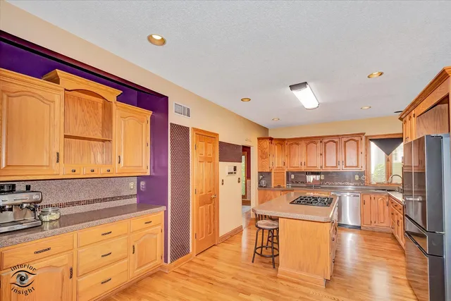 a kitchen with stainless steel appliances granite countertop a refrigerator and a stove top oven