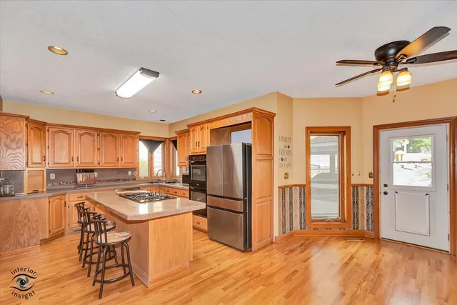 a kitchen with stainless steel appliances granite countertop a stove a sink and a refrigerator