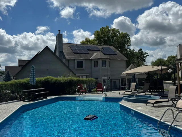 a swimming pool with outdoor seating water slide and a yard