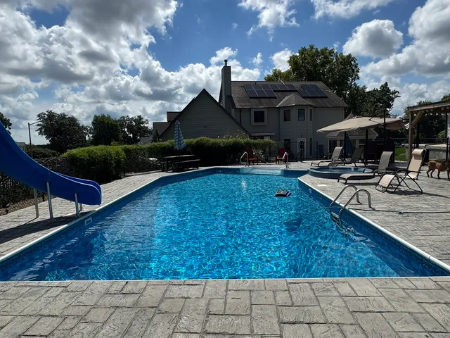 a view of a house with swimming pool and sitting area