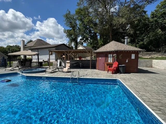 a view of a swimming pool with sitting area and furniture