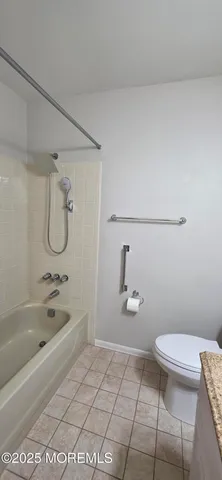 a bathroom with a granite countertop toilet a sink and bathtub