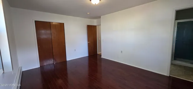 an empty room with wooden floor and closet
