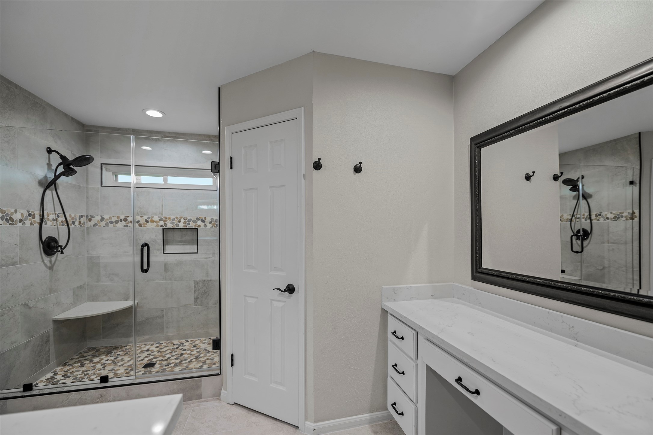6507 Allentown Drive Spring, TX 77389 - Photo 9 of 30 The primary bath boasts an elegant mirror, a sitting vanity with storage, and a custom oversized shower equipped with a shower seat and dual closets.