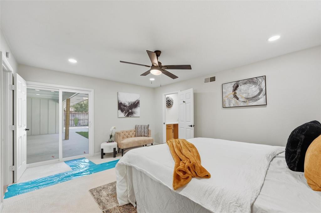 2709 Quail Ridge Drive Carrollton, TX 75006 - Photo 13 of 28 a bedroom with a large bed and a chandelier