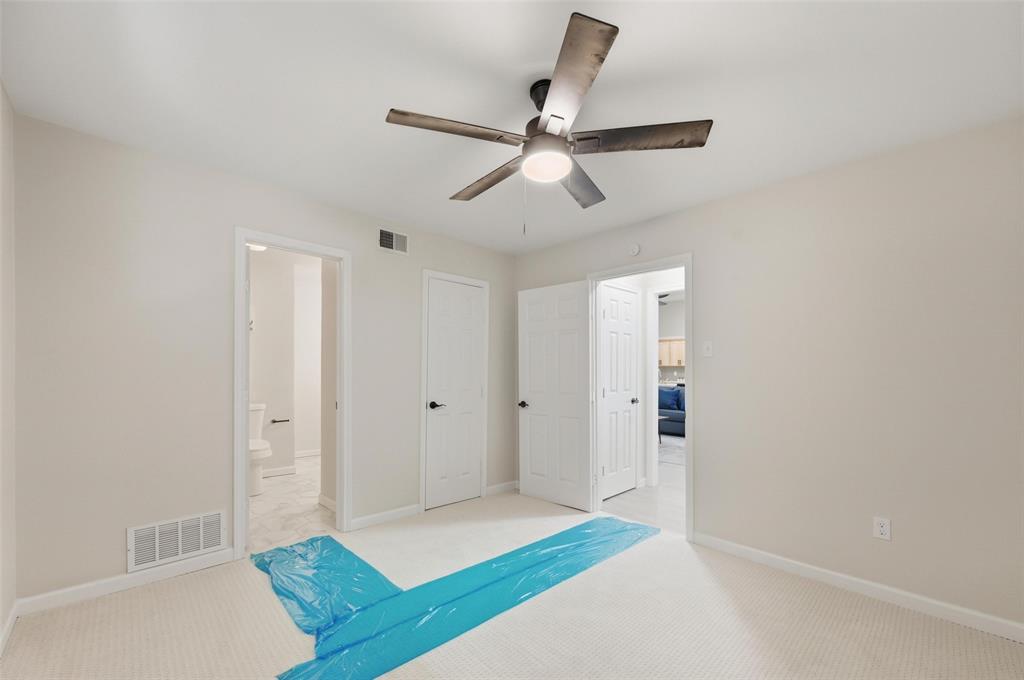 2709 Quail Ridge Drive Carrollton, TX 75006 - Photo 19 of 28 a bedroom with a bed and a ceiling fan