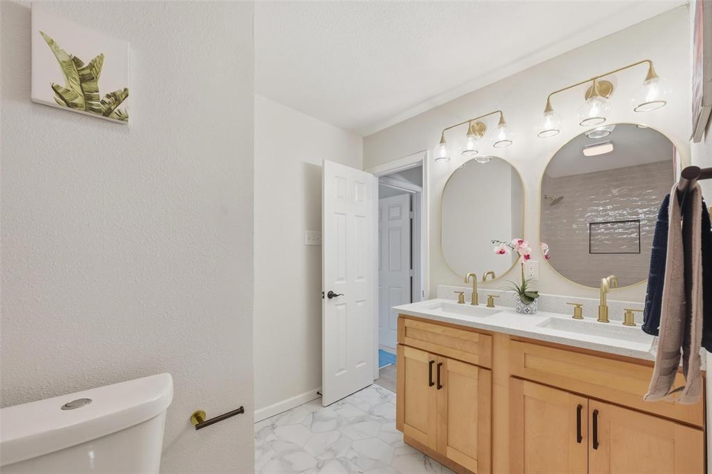 2709 Quail Ridge Drive Carrollton, TX 75006 - Photo 20 of 28 a bathroom with a double vanity sink mirror and toilet