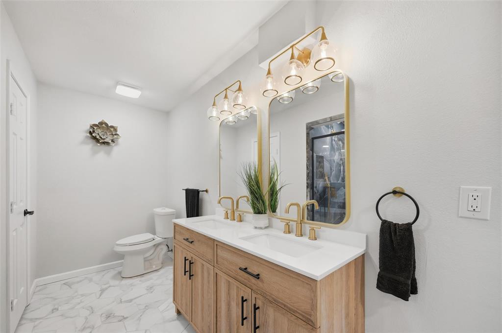 2709 Quail Ridge Drive Carrollton, TX 75006 - Photo 22 of 28 a bathroom with a sink vanity and a mirror