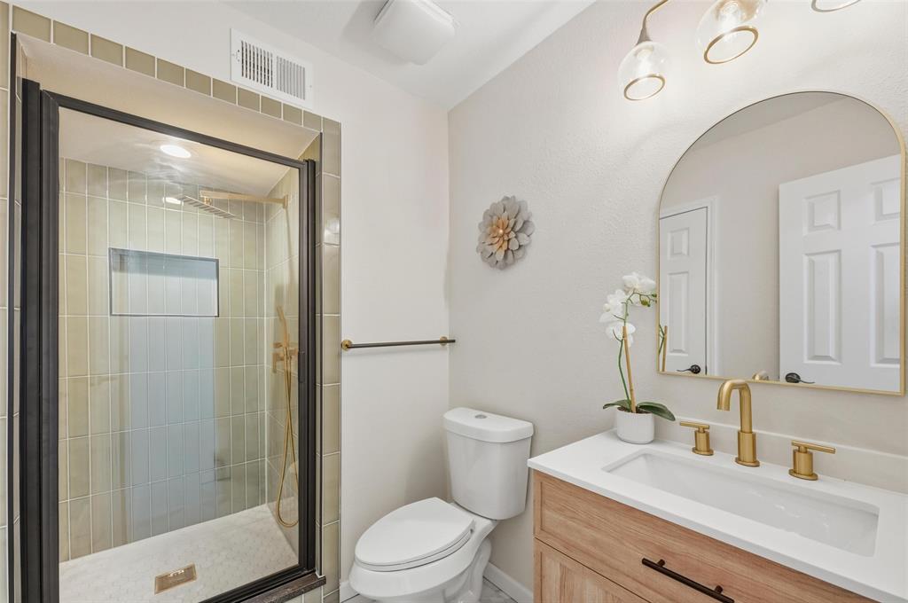 2709 Quail Ridge Drive Carrollton, TX 75006 - Photo 24 of 28 a bathroom with a sink a toilet and shower