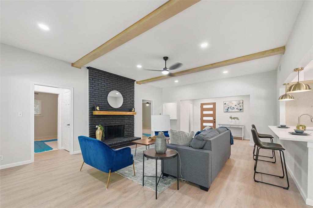 2709 Quail Ridge Drive Carrollton, TX 75006 - Photo 3 of 28 a living room with furniture a fireplace and a flat screen tv