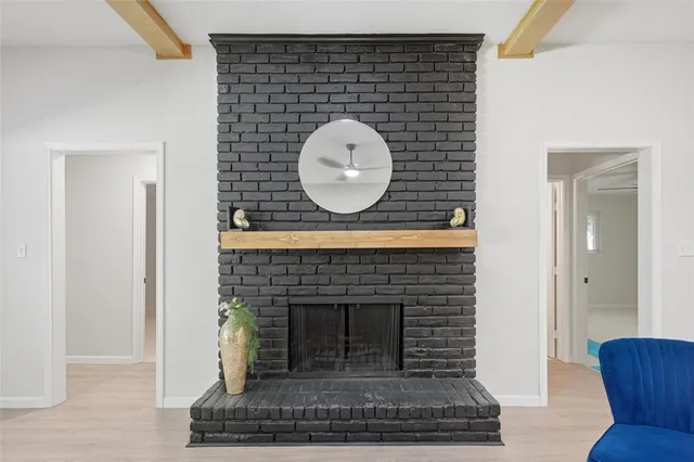a living room with a fireplace and a potted plant
