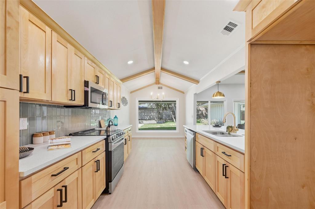 2709 Quail Ridge Drive Carrollton, TX 75006 - Photo 8 of 28 a kitchen with stainless steel appliances a sink stove and cabinets