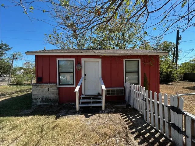 a view of house with backyard and trees