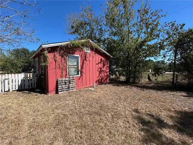 a view of a wooden house with a large trees