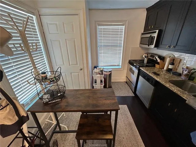 a view of a kitchen with dining table and chairs