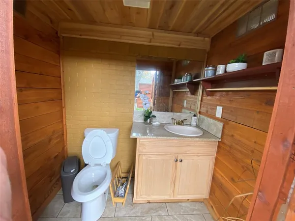 a bathroom with a granite countertop toilet sink and mirror
