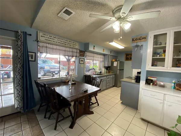 a kitchen with a dining table chairs and view of living room