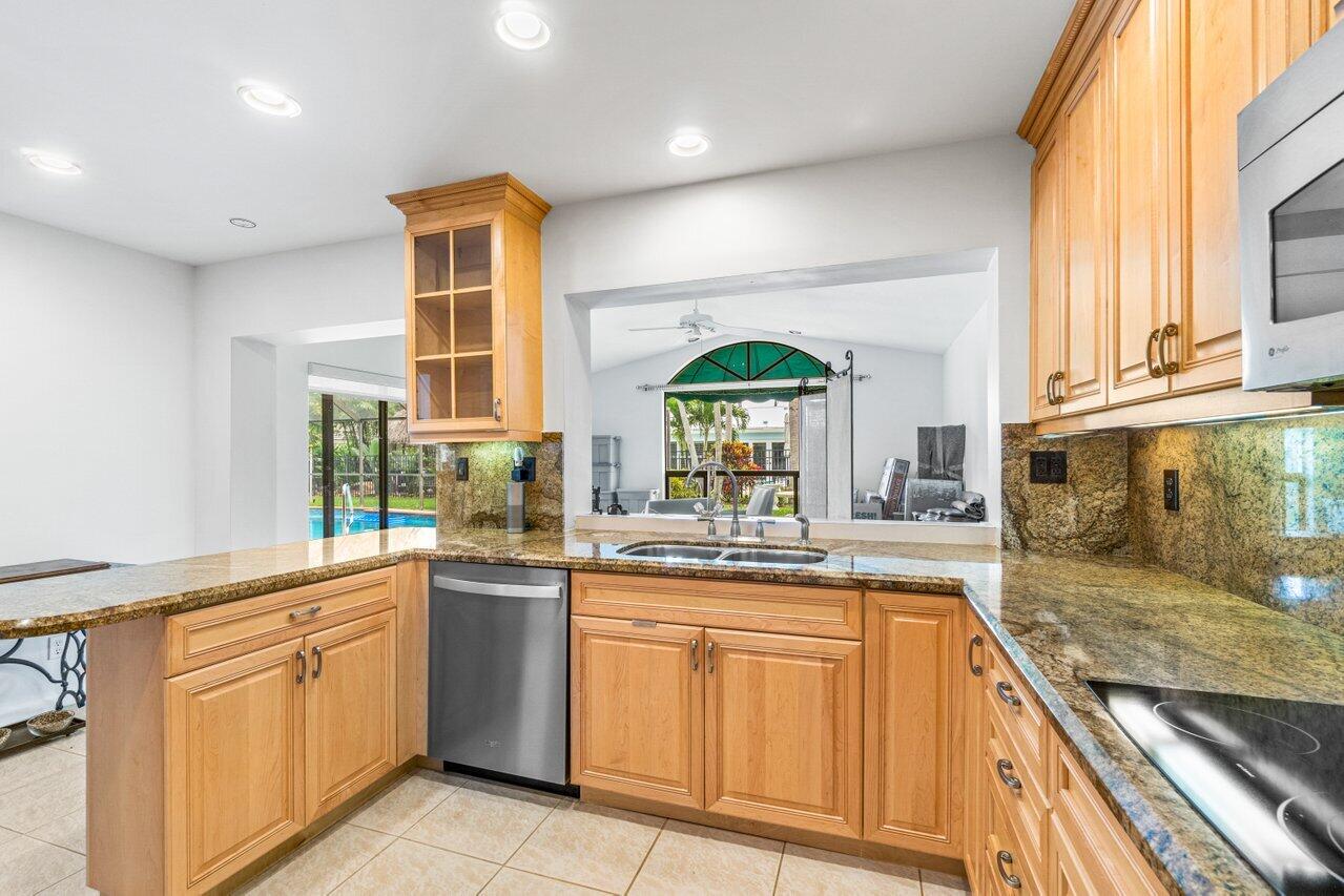 1350 Southwest 13th Place Boca Raton, FL 33486 - Photo 8 of 26 a kitchen with stainless steel appliances granite countertop a stove a sink and a microwave