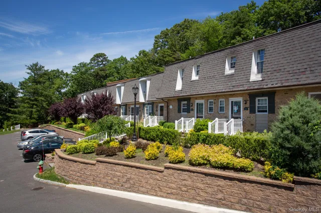 a front view of a house with a yard and potted plants