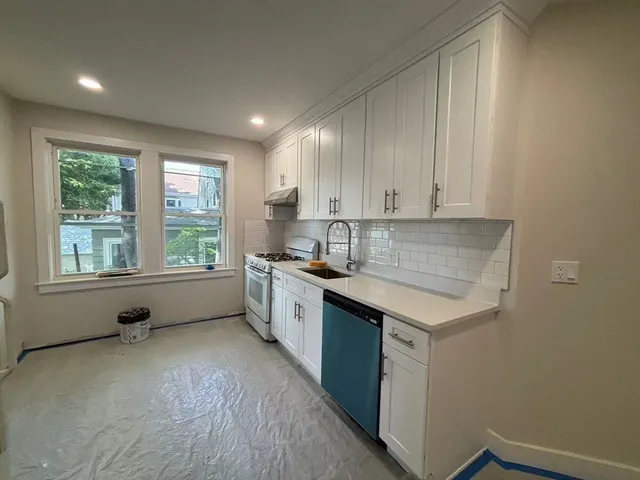 a kitchen with a sink window and cabinets