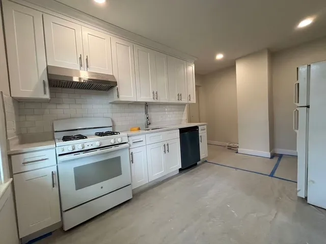 a kitchen with stainless steel appliances granite countertop a stove a sink and a refrigerator