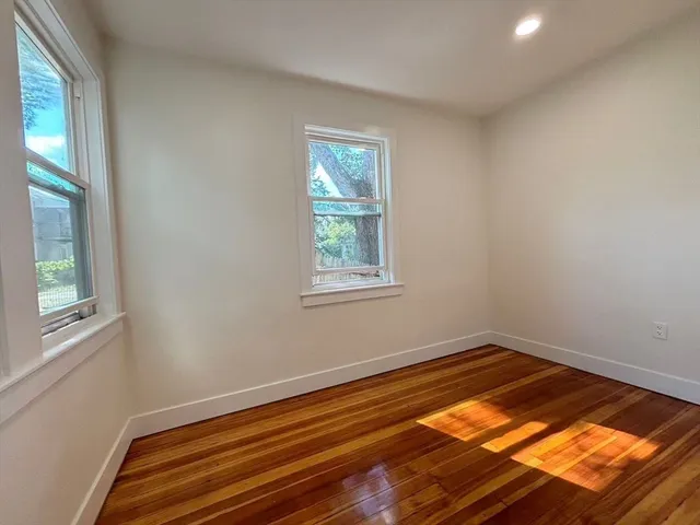 a view of a room with wooden floor and windows