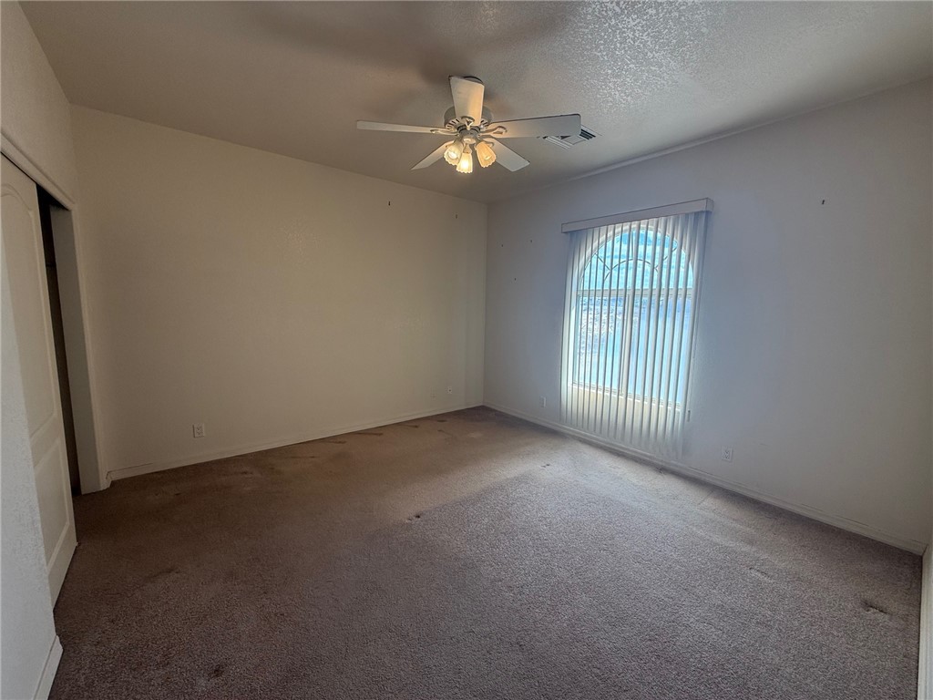 1845 Dunlap Road Fort Mohave, AZ 86426 - Photo 6 of 16 Unfurnished room with carpet, a textured ceiling, and ceiling fan