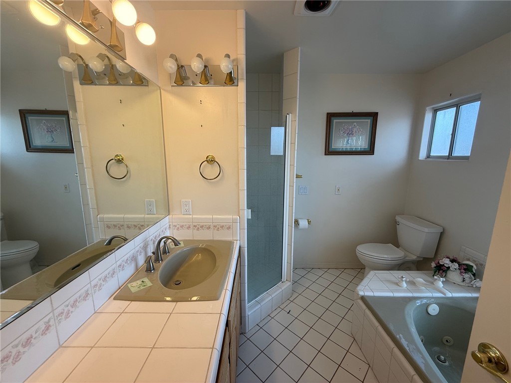 1845 Dunlap Road Fort Mohave, AZ 86426 - Photo 7 of 16 Bathroom featuring a whirlpool tub, light tile patterned floors, vanity, and a stall shower