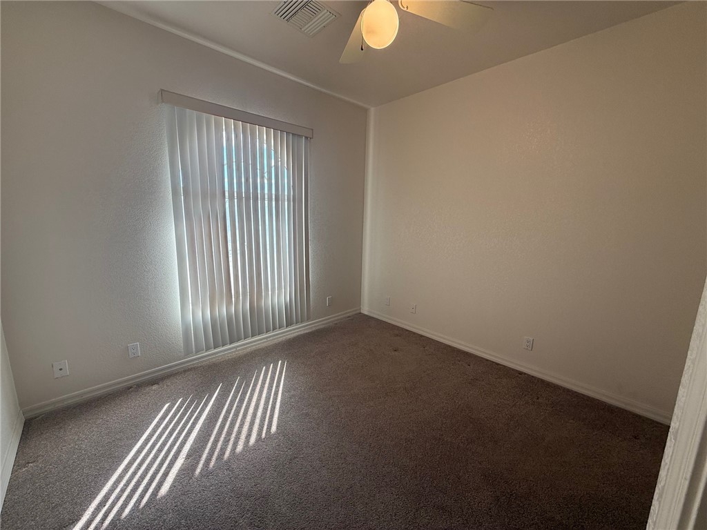 1845 Dunlap Road Fort Mohave, AZ 86426 - Photo 8 of 16 Empty room featuring carpet flooring, a textured wall, and a ceiling fan