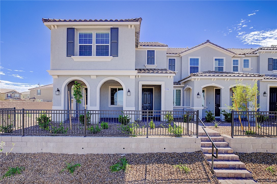 Mediterranean / spanish house featuring stucco siding, covered porch, and a tile roof