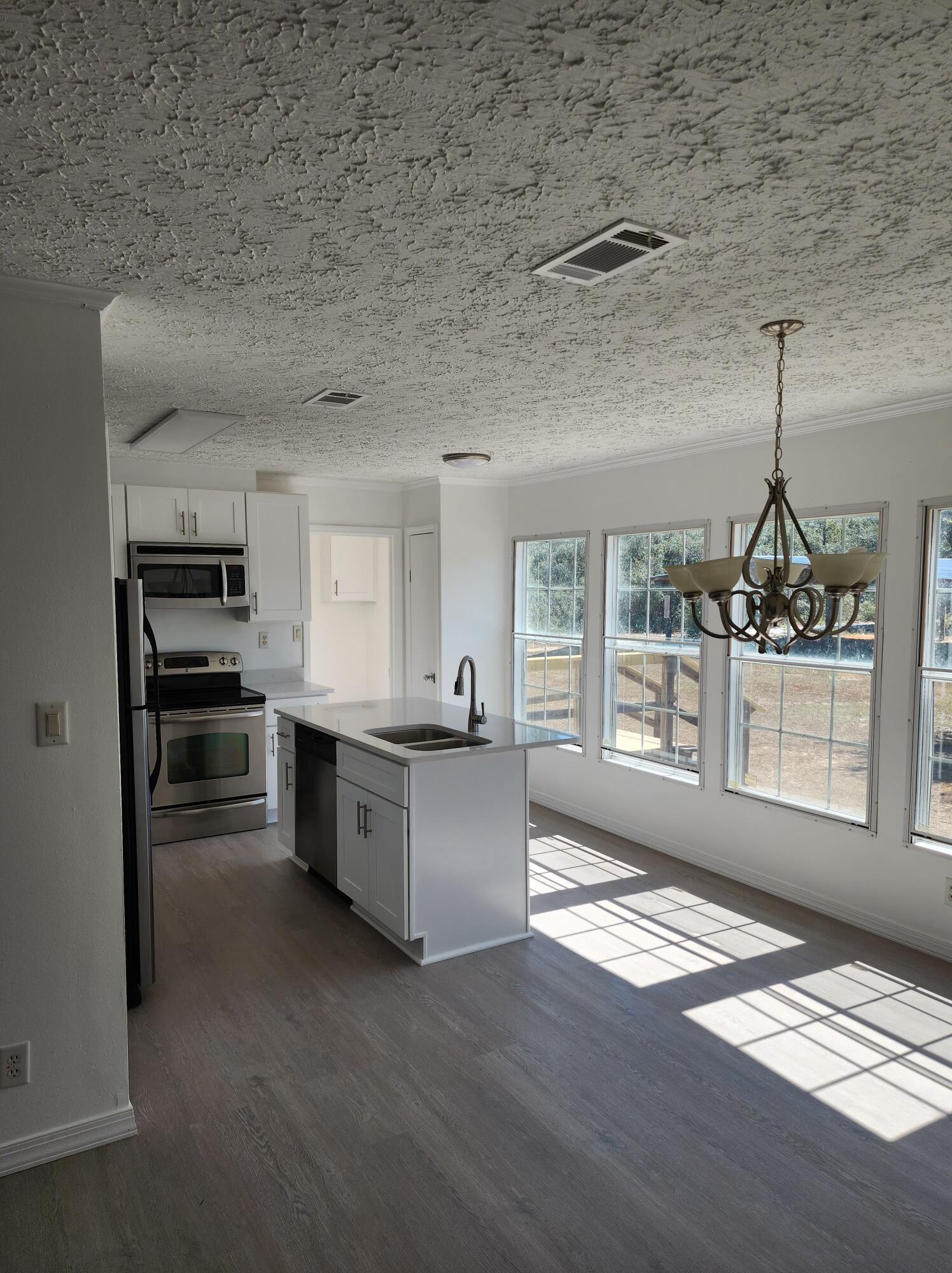 268 Don Graff Road Freeport, FL 32439 - Photo 6 of 20 a large kitchen with cabinets wooden floor and stainless steel appliances