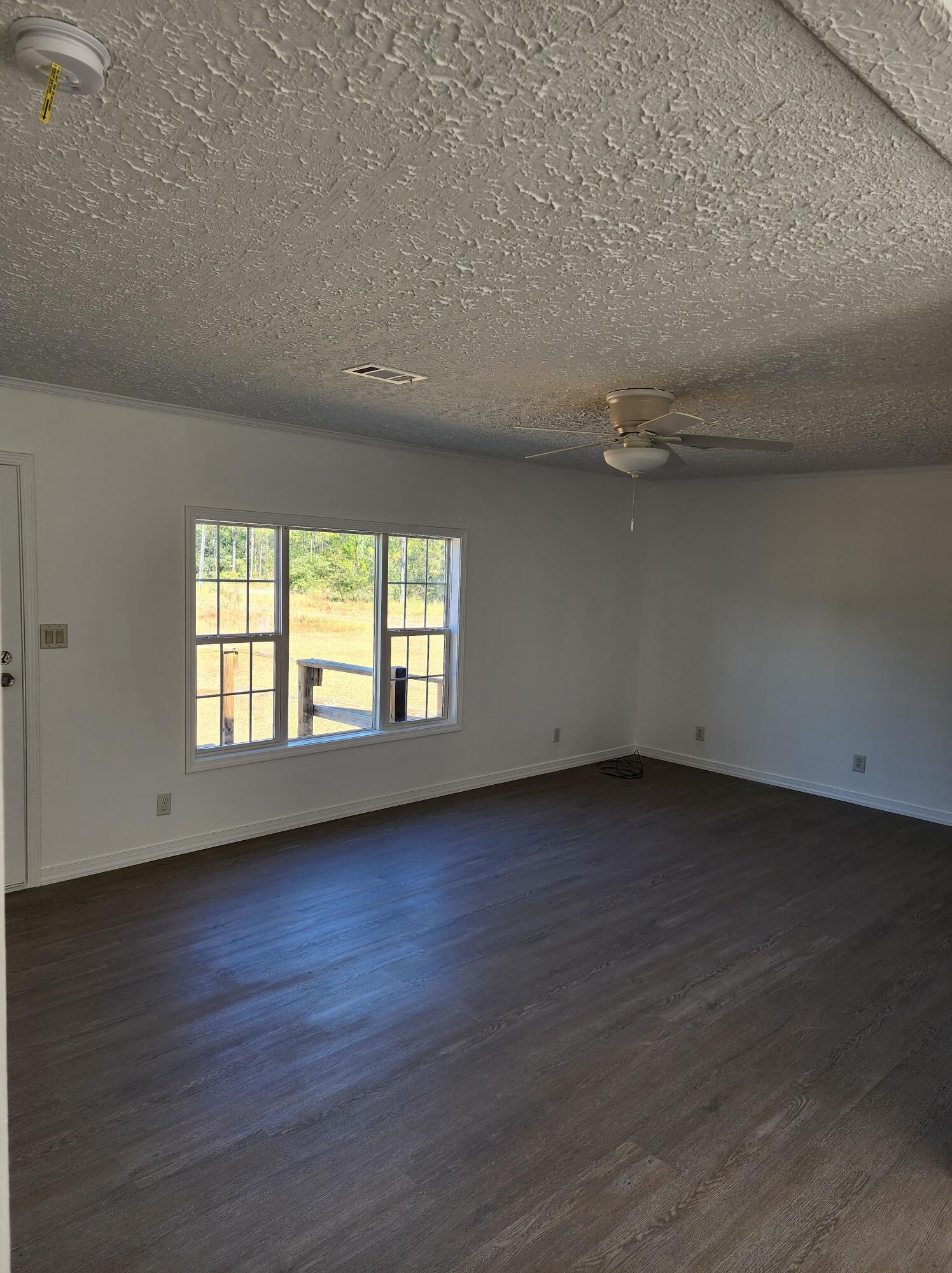 268 Don Graff Road Freeport, FL 32439 - Photo 7 of 20 an empty room with wooden floor and windows