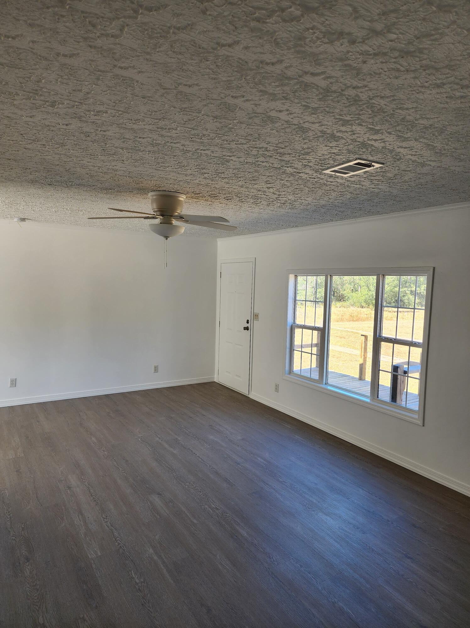 268 Don Graff Road Freeport, FL 32439 - Photo 8 of 20 an empty room with wooden floor and windows