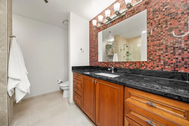 a bathroom with a granite countertop sink and a mirror