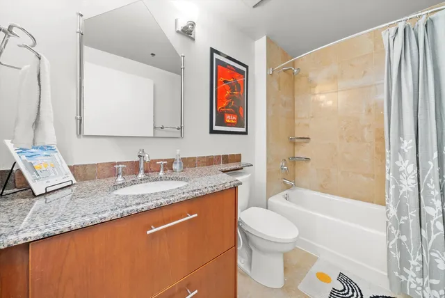 a bathroom with a granite countertop sink toilet and shower