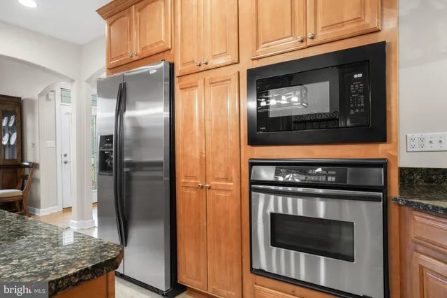 a kitchen with granite countertop stainless steel appliances and wooden cabinets