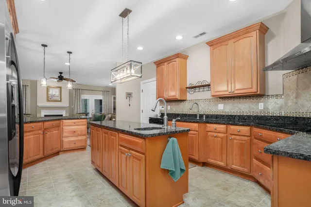 a large kitchen with stainless steel appliances granite countertop a sink and cabinets