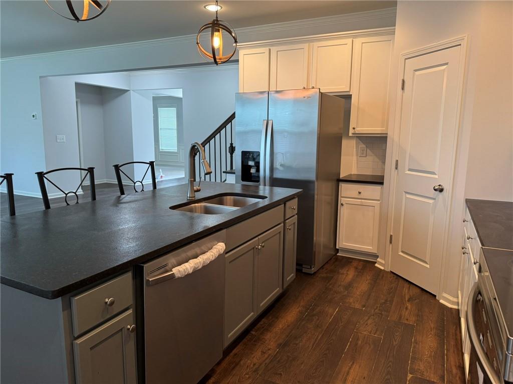 5414 Long Branch Way Flowery Branch, GA 30542 - Photo 11 of 37 a kitchen with stainless steel appliances granite countertop a refrigerator a sink a stove and white cabinets with wooden floor