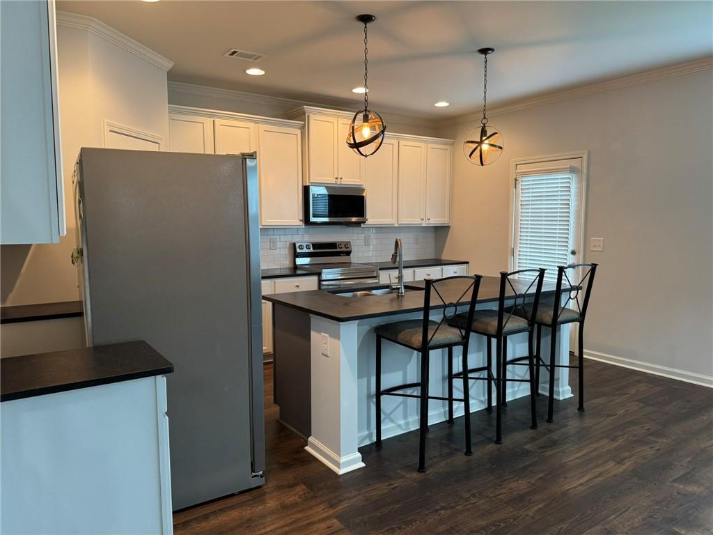 5414 Long Branch Way Flowery Branch, GA 30542 - Photo 13 of 37 a kitchen with stainless steel appliances granite countertop a stove a refrigerator a kitchen island a sink and a refrigerator