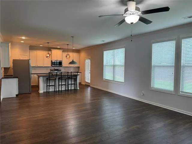 an open kitchen with wooden floor and stainless steel appliances