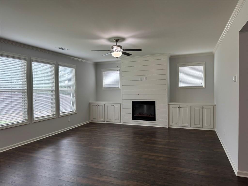 5414 Long Branch Way Flowery Branch, GA 30542 - Photo 17 of 37 an empty room with wooden floor fireplace and windows