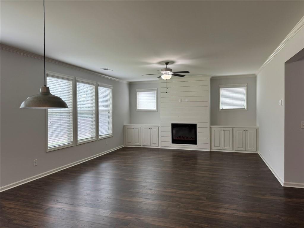 5414 Long Branch Way Flowery Branch, GA 30542 - Photo 19 of 37 an empty room with wooden floor fireplace and windows