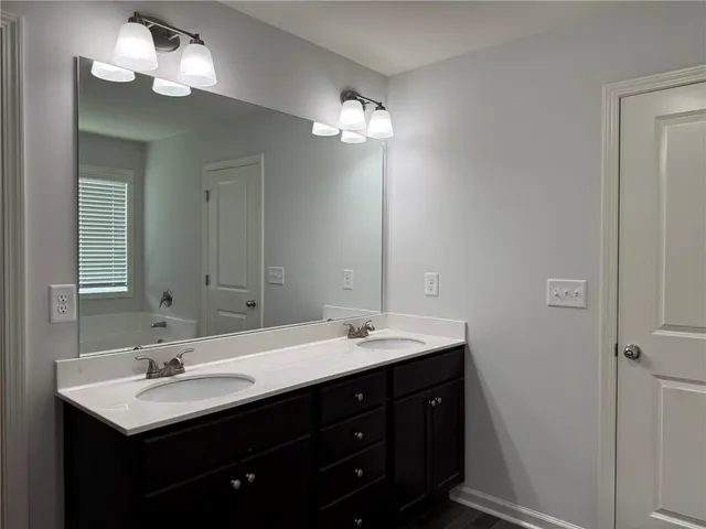 a bathroom with a double vanity sink and a mirror