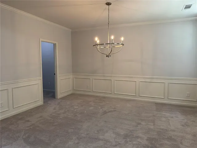 a view of an empty room with chandelier