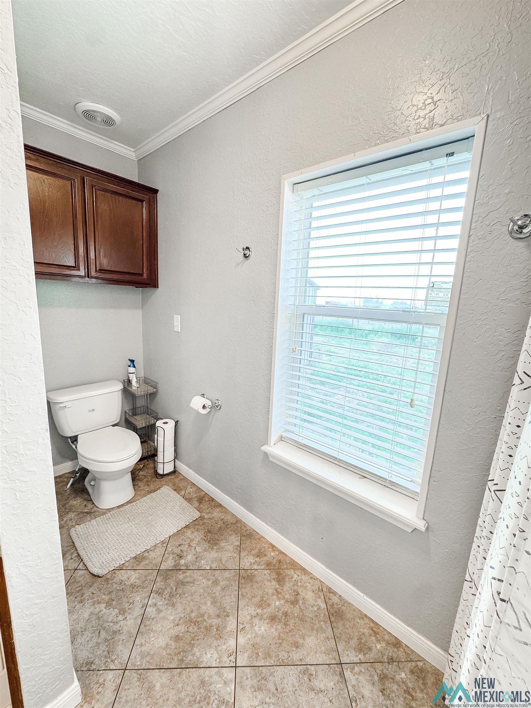 309 Crossbow Road Artesia, NM 88210 - Photo 21 of 31 Tiled flooring with white baseboards and crown molding
